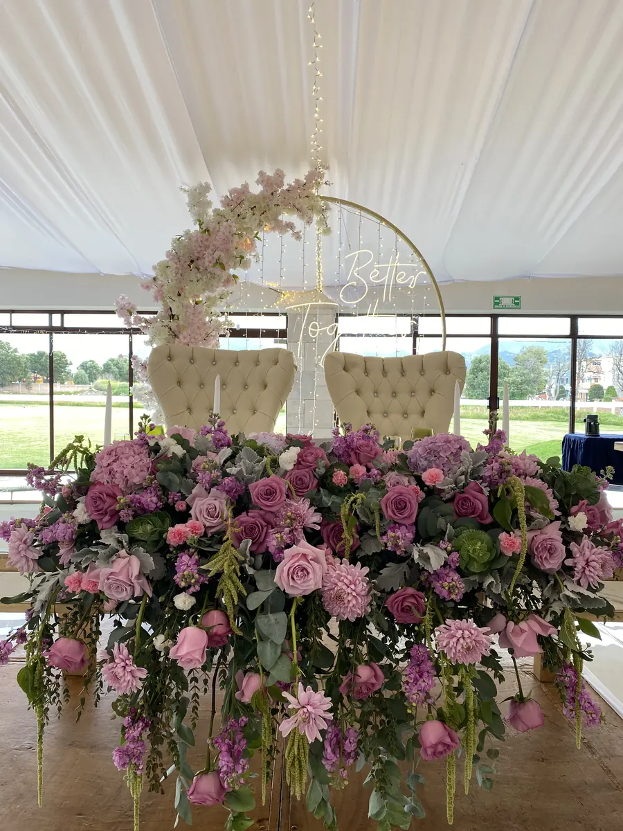 Mesa de honor con aro dorado, sillones y flores rosas