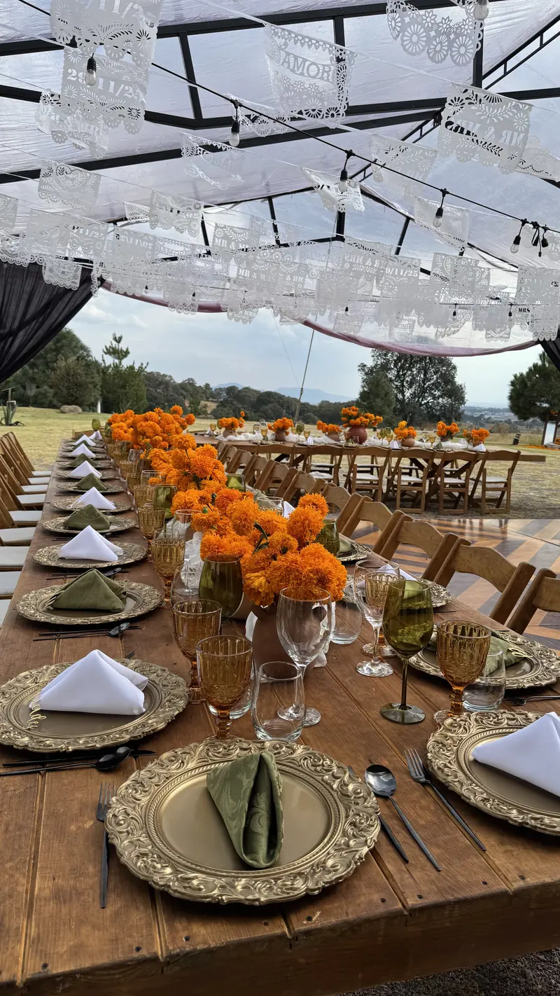 Mesa imperial con cempasúchil, servilletas verdes y luces colgantes