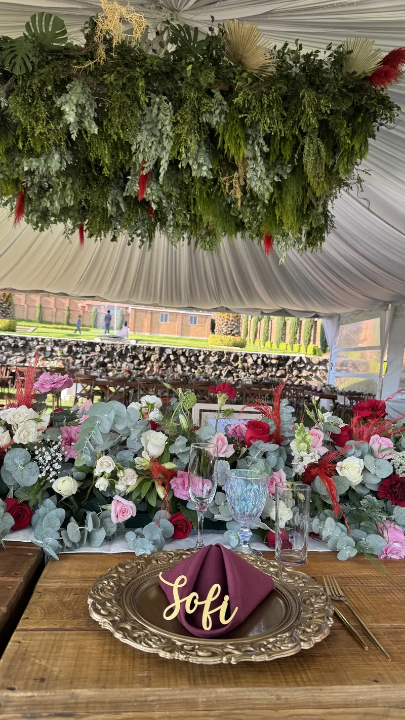 Mesa con techo de follaje y muro de flores