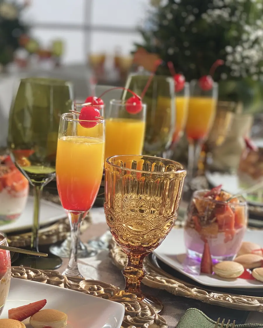 Cócteles de colores en copas flauta con cereza